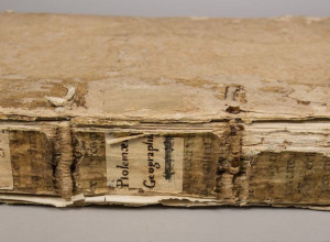 : An image of the spine and binding of the “Geographia” before conservation treatment