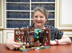Teresa Elsmore with a fantastical lego library model which forms part of the National Library of Scotland's centenary exhibition 'Dear Library'