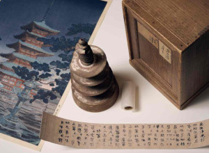 Hyakumantō Darani with wooden pagoda, storage box and facsimile text alongside a colour woodblock print of Horyuji Temple in Nara, Japan, where this particular darani was stored. Photo: Eugene Hyland. 