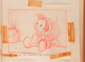 Sketch of Disney's Pinocchio in red, mounted with tape to a sketchbook page.