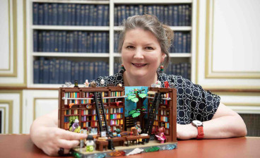 Teresa Elsmore with a fantastical lego library model which forms part of the National Library of Scotland's centenary exhibition 'Dear Library'