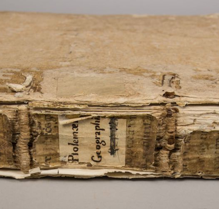 : An image of the spine and binding of the “Geographia” before conservation treatment